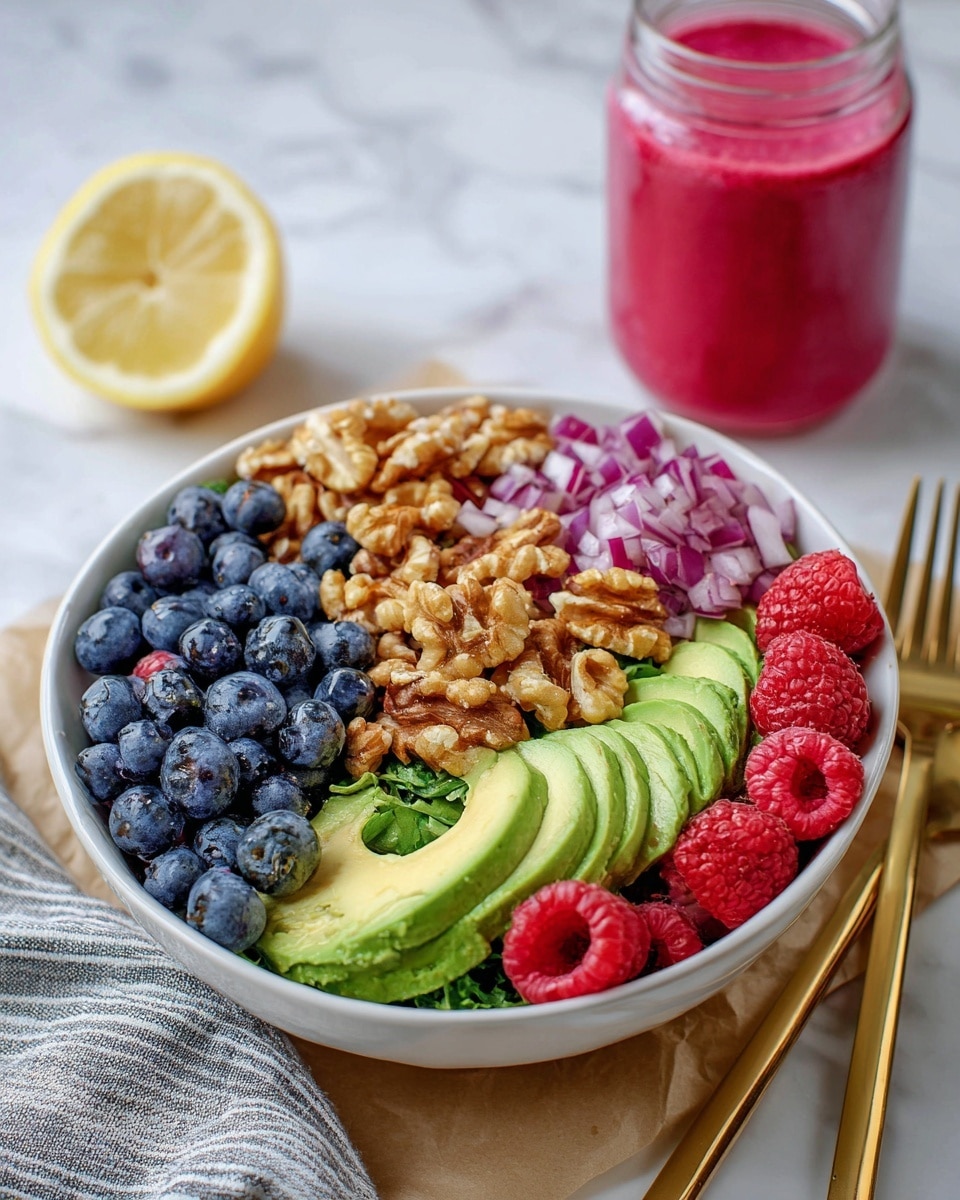 A white bowl is filled with six layers: fresh raspberries that are bright red and textured at the bottom left, sliced avocado in light green with creamy smooth texture next to the raspberries, finely chopped red onions with purple and white shades in the middle, a heap of crunchy raw walnuts in light brown on the top right, and fresh blueberries that are dark blue filling the top left side of the bowl. The bowl is placed on a piece of brown parchment paper over a white marbled surface. To the right of the bowl, there is a gold fork and knife set. A glass jar with a pink smoothie and a lemon sit in the background. A woman's hand holding the golden fork is shown on the right side of the image. photo taken with an iphone --ar 4:5 --v 7