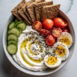 Savory Yogurt Bowl with Crackers, Cherry Tomatoes, Egg, and Cucumber Recipe