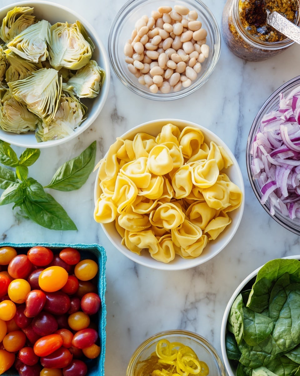 The image shows a variety of fresh ingredients arranged on a white marbled surface. At the center, there is a large pile of yellow tortellini pasta with smooth, folded shapes. On the top left, there is a white bowl filled with pale green artichoke hearts, layered in half. Next to it, a small glass bowl holds light beige beans. To the right, there is a glass jar with a brownish herb dressing and a spoon inside. Below the jar, a blue carton holds red and orange cherry tomatoes scattered around it. At the bottom right, a white bowl contains thinly sliced purple onions. At the bottom left, a white bowl is filled with bright green spinach leaves, while a small glass bowl with yellow pickled peppers is next to it. Fresh basil leaves lie near the top left on the white marbled surface. Photo taken with an iphone --ar 4:5 --v 7