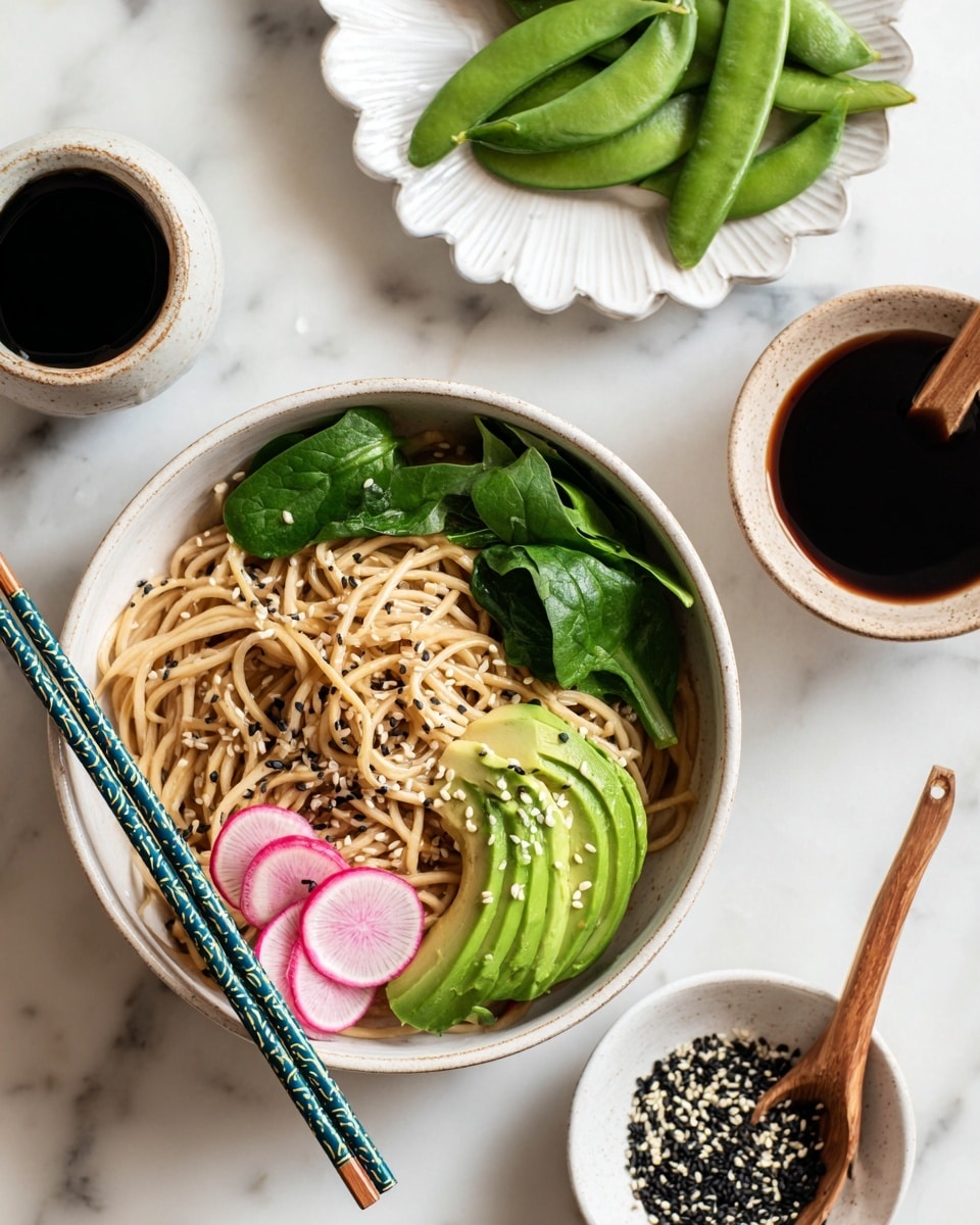 A white bowl filled with light brown noodles topped with thin green avocado slices arranged on one side, light pink radish slices, and fresh green spinach leaves. There are small black and white sesame seeds sprinkled over the dish. Two chopsticks with blue and green handles rest on the bowl's edge. Nearby, a small white bowl contains black and white sesame seeds, and a small white bowl holds dark soy sauce with a wooden spoon. Green sugar snap peas lie on a white scalloped plate. The surface is white marble. Photo taken with an iphone --ar 4:5 --v 7