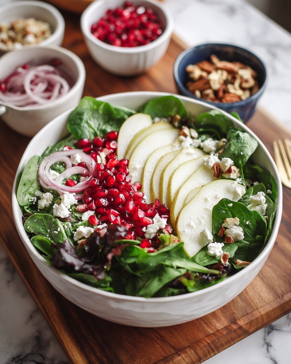 A white bowl filled with a fresh green salad sits on a wooden board with a white marbled surface underneath. The salad has several layers starting with dark and light green leafy spinach and mixed greens at the bottom, topped with thin slices of pear on one side. Scattered over the salad are bright red pomegranate seeds adding vibrant color, while white crumbles of cheese sit on top adding a soft texture. Thin slices of red onion are lightly mixed within the leaves, and small bits of nuts are sprinkled over everything. Around the bowl, small white and blue bowls hold more pomegranate seeds and nuts. Photo taken with an iphone --ar 4:5 --v 7