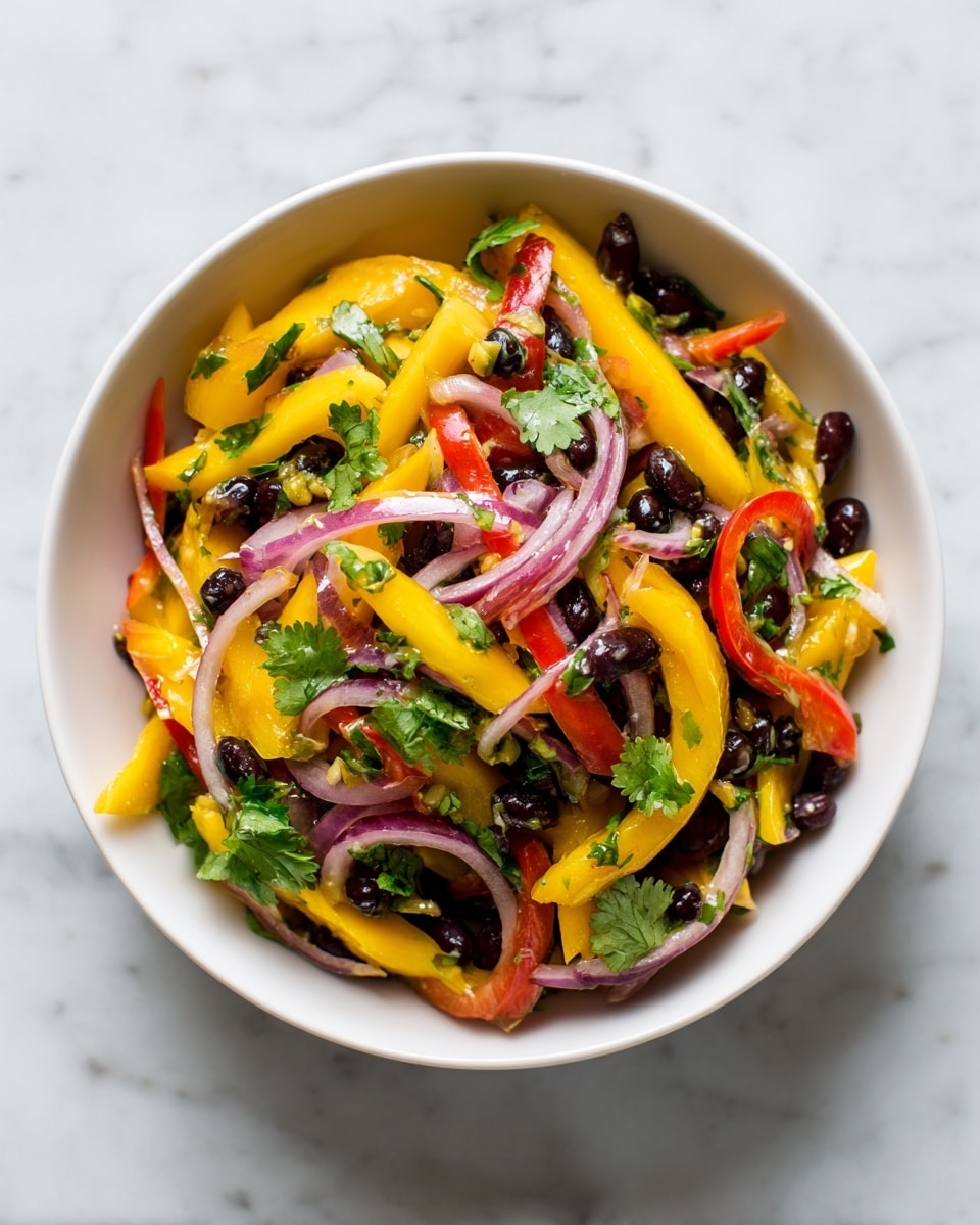 A white bowl filled with a colorful salad that has three main layers: thin strips of yellow mango as the bottom layer, followed by a mix of sliced red bell peppers and thin red onion rings spread on top, and scattered black beans adding dark round shapes throughout. Fresh green herbs like cilantro are mixed evenly, adding small green leaves across the salad. The bowl sits on a white marbled surface. photo taken with an iphone --ar 4:5 --v 7