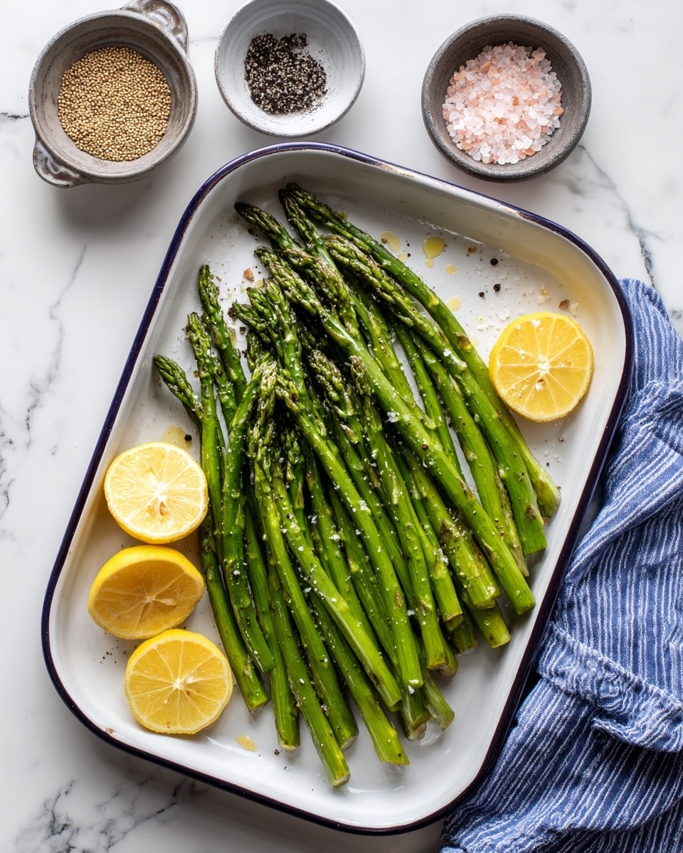 The image shows a white rectangular tray with a single layer of grilled green asparagus spears neatly arranged side by side. The asparagus has a slightly charred texture with visible grill marks along its length. A woman's hand holds the tray while using black and silver tongs to pick up one of the spears. The background features a grill with more asparagus and yellow lemons in soft focus. The surface below is white marbled texture. photo taken with an iphone --ar 4:5 --v 7