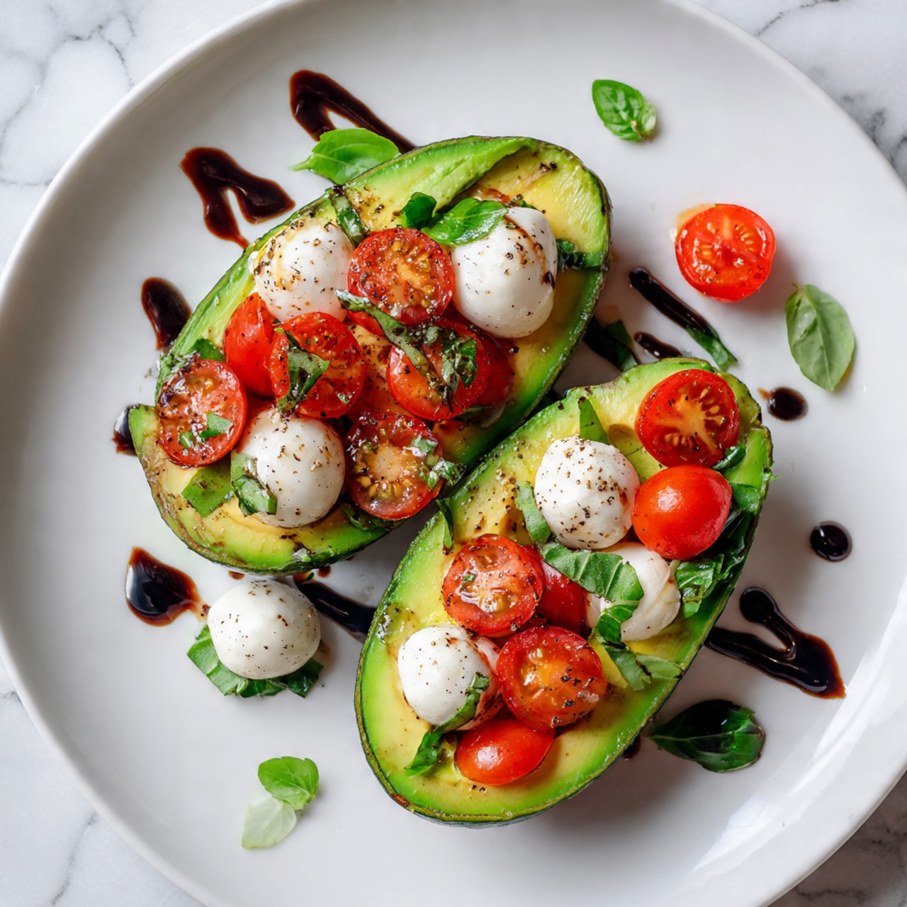 A white plate on a white marbled surface holds two avocado halves filled with a colorful mix. Each avocado half is bright green with a smooth texture, topped with small, round red cherry tomatoes and white mozzarella balls. The mozzarella balls have a soft texture and are speckled with black pepper and small green basil leaves. A few drops of dark balsamic glaze are artistically drizzled on the avocados and on the plate around them. The colors of the avocado, tomatoes, mozzarella, and basil create a fresh and vibrant look. photo taken with an iphone --ar 4:5 --v 7