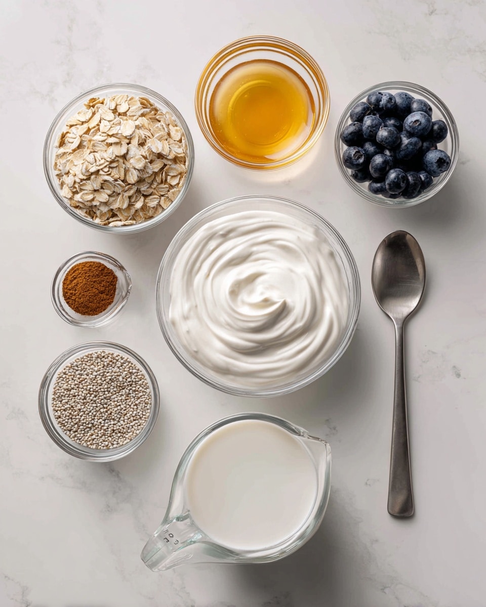 The image shows seven small containers placed on a white marbled surface. In the center is a clear white glass bowl filled with thick white yogurt that has a smooth, swirled texture. To the bottom left is another clear white glass bowl holding light beige rolled oats with a rough texture. Below the yogurt bowl is a clear white measuring cup with a handle, filled halfway with a white liquid, likely milk. To the right of the milk is a small clear white glass bowl filled with golden honey, showing a shiny and smooth surface. Above the honey is an even smaller clear white glass bowl holding a small pile of fine cinnamon, dark orange-brown in color. To the top right, there is a metal measuring spoon filled with fresh blueberries, dark blue and glossy. To the left of the spoon is another clear white glass bowl containing small, beige chia seeds with a grainy texture. The arrangement is neat and spaced, with natural light highlighting the textures and colors of the ingredients photo taken with an iphone --ar 4:5 --v 7