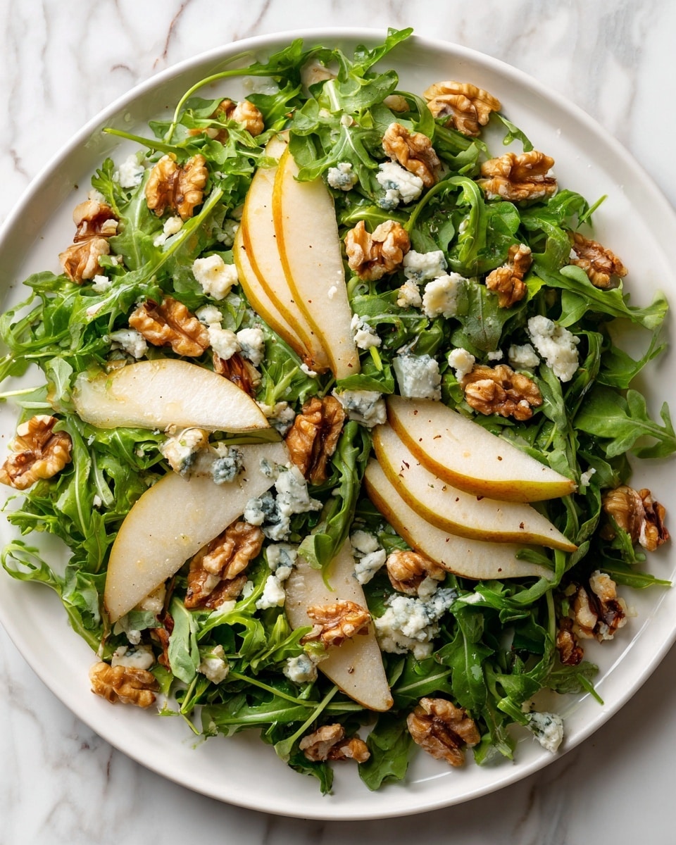 The image shows a white plate with a bed of bright green leafy arugula as the base layer. On top, there are thin slices of light brown pear arranged neatly. Small chunks of blue cheese with a crumbly texture are scattered over the pears. Pieces of golden brown walnuts are also spread across the plate, adding a crunchy look. Everything is layered evenly, creating a fresh and colorful salad. The background surface has a white marbled texture. photo taken with an iphone --ar 4:5 --v 7