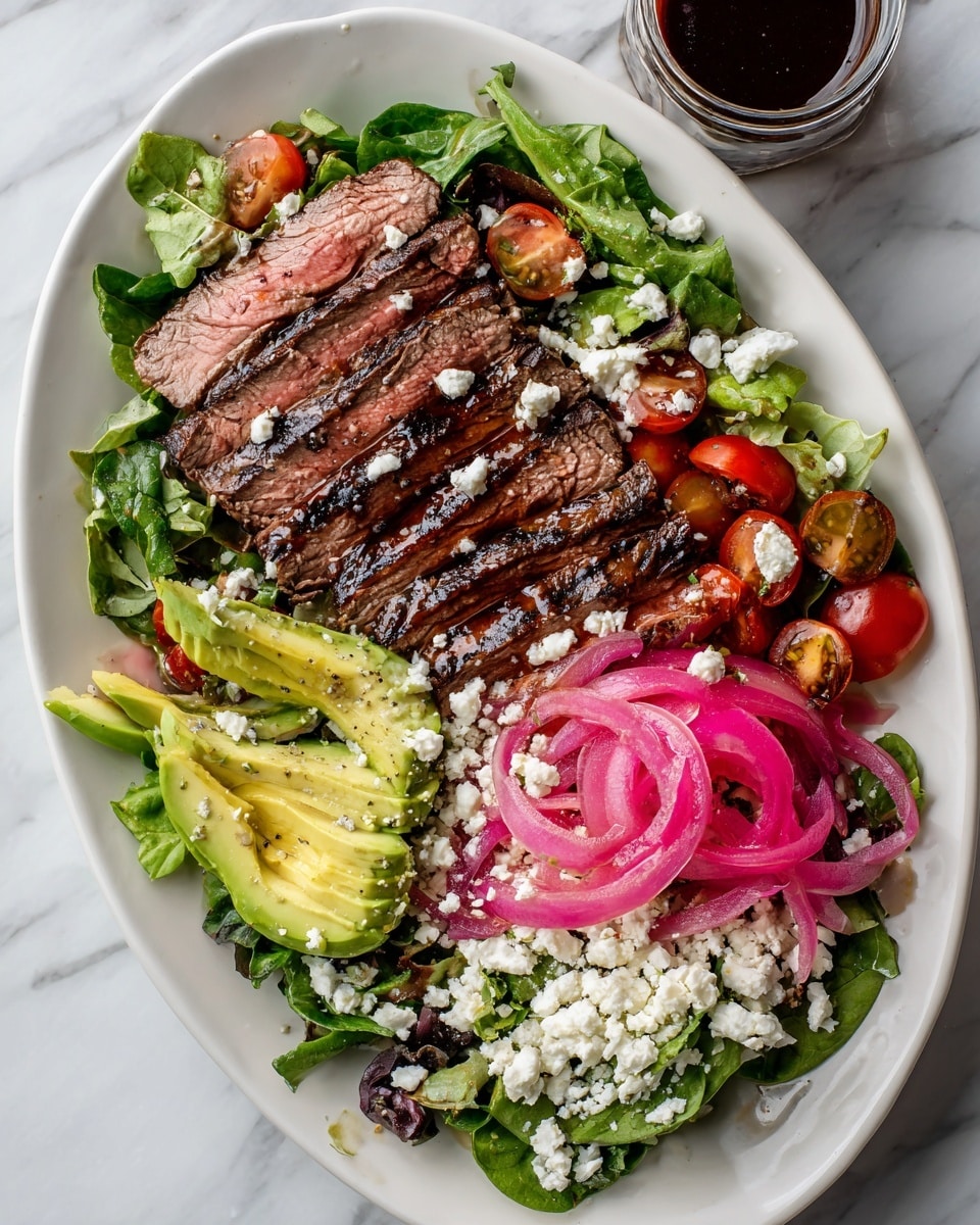 A large white oval plate holds a fresh salad layered with green leafy lettuce as the base, scattered with halved red cherry tomatoes and bright pink pickled onions. On top, there are several slices of grilled steak arranged in three neat rows, showing a juicy pink center with dark grill marks on the edges. Creamy white cheese crumbles are sprinkled over the salad and steak, with sliced green avocado pieces placed around, some drizzled with a dark balsamic glaze. The plate sits on a white marbled surface with a clear glass jar of dark dressing nearby and a few cherry tomatoes off to the side. Photo taken with an iphone --ar 4:5 --v 7