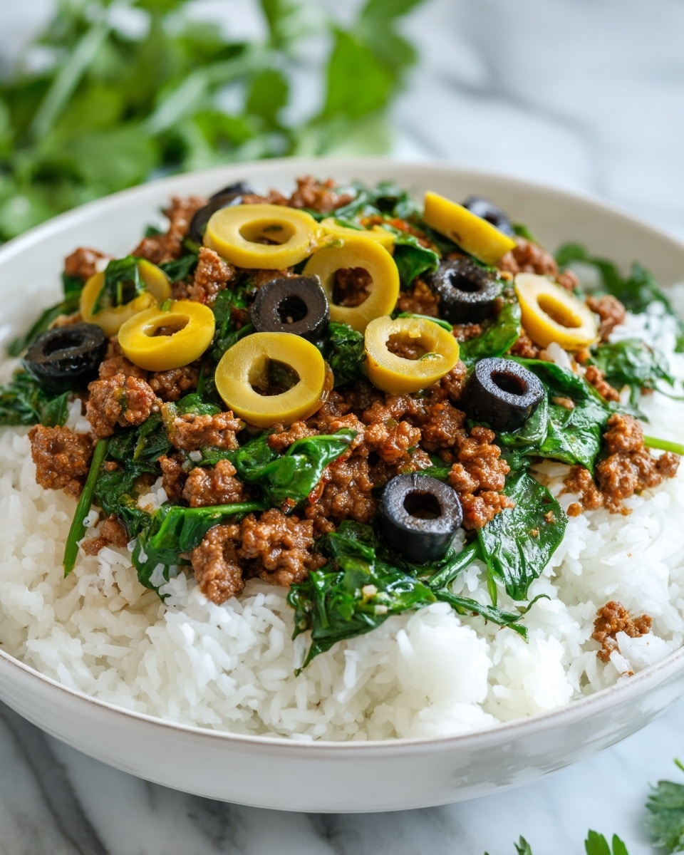 A bowl with three main layers is shown: the bottom layer is white fluffy rice, the middle layer is a mix of cooked ground meat with bright green spinach leaves and chunks of translucent cooked onion, and the top layer includes halved green and purple olives scattered over the meat and spinach. The bowl is white with a gray patterned rim, placed on a white marbled surface with fresh green herbs in the background. photo taken with an iphone --ar 4:5 --v 7