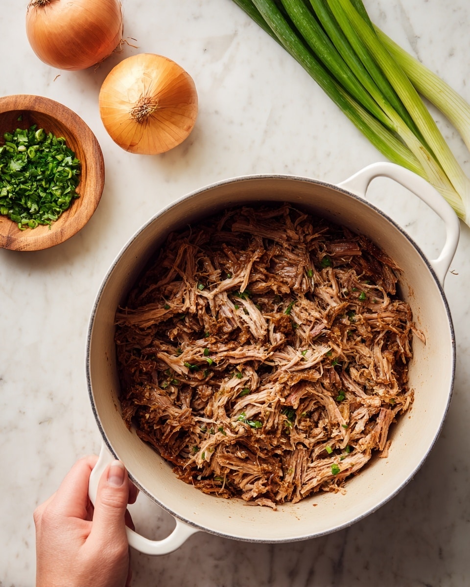 The image shows a white pot filled with cooked, shredded brown meat with a slight pink center, mostly covering the bottom of the pot. The pot is placed on a white marbled surface. Nearby, on the surface, there is a small wooden bowl with green finely chopped herbs, a whole orange onion, and several long green onions with white bulbs. A woman's hand is holding the handle of the pot. Photo taken with an iphone --ar 4:5 --v 7