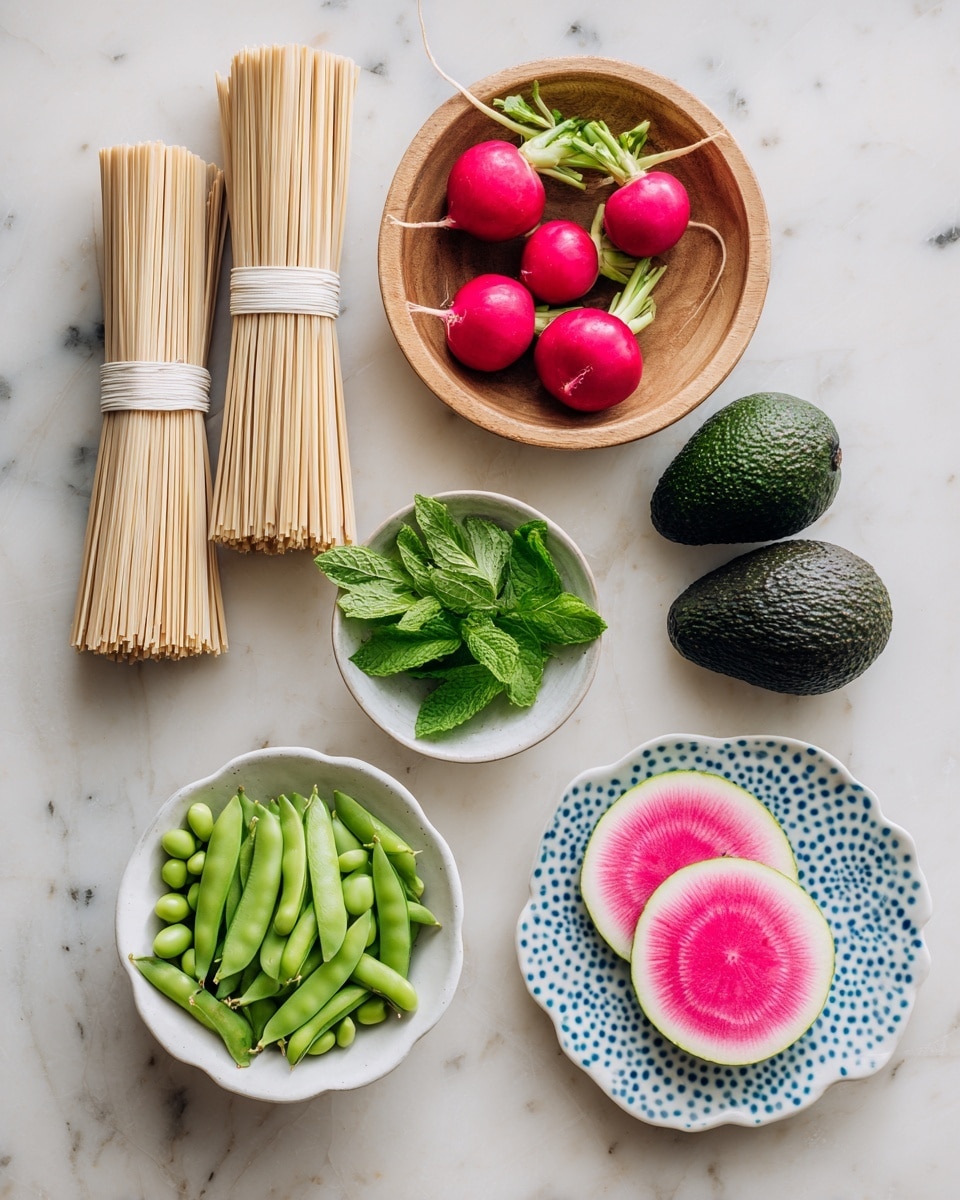 The image shows several fresh ingredients arranged neatly on a white marbled surface. At the top left, there are two bundles of beige dried noodles tied with white bands, and to the right of them is a round wooden bowl holding four small red radishes with green tops. Below the radishes, there are two dark green avocados placed side by side. At the bottom left, a small white bowl is filled with bright green edamame beans. To the right of the avocados is a scalloped white bowl with green sugar snap peas inside. Above the sugar snap peas, a small white plate with blue dots around the edge holds fresh green mint leaves. Near the center right, two round slices of a watermelon radish display a white outer layer with a bright pink center. The overall setup is clean and colorful, showing a variety of fresh, raw ingredients ready for cooking. photo taken with an iphone --ar 4:5 --v 7