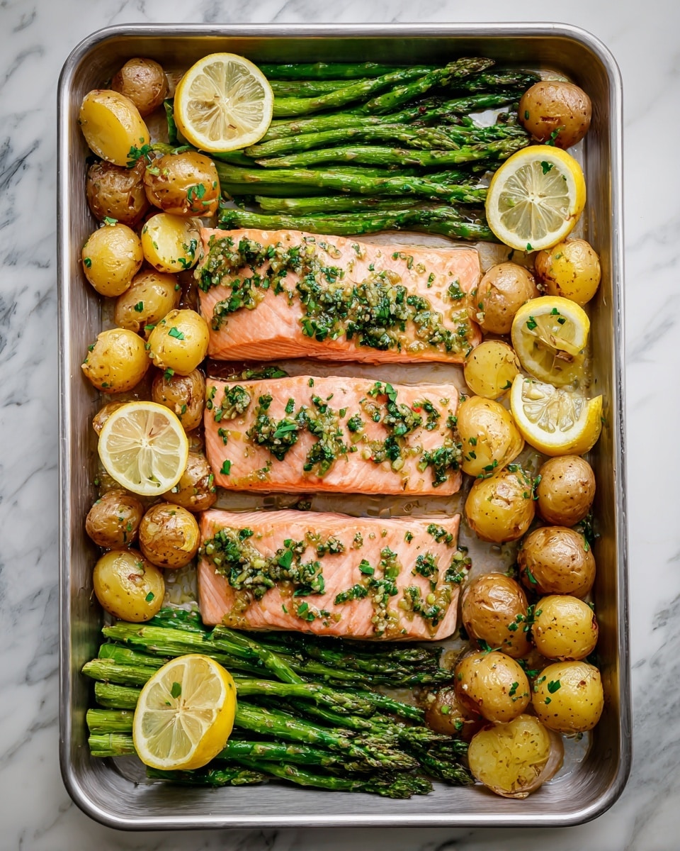 A dark baking tray holds three pieces of cooked salmon fillets arranged in a row, each topped with chopped green herbs and slices of yellow lemon. Around the salmon, small golden-brown roasted potatoes fill the edges of the tray, some cut in half showing their soft yellow inside. On each side of the salmon, bright green cooked asparagus spears are placed neatly with a few lemon slices on top. The tray rests on a white marbled surface with small clear bowls of herbs and spices visible near the top left corner. photo taken with an iphone --ar 4:5 --v 7