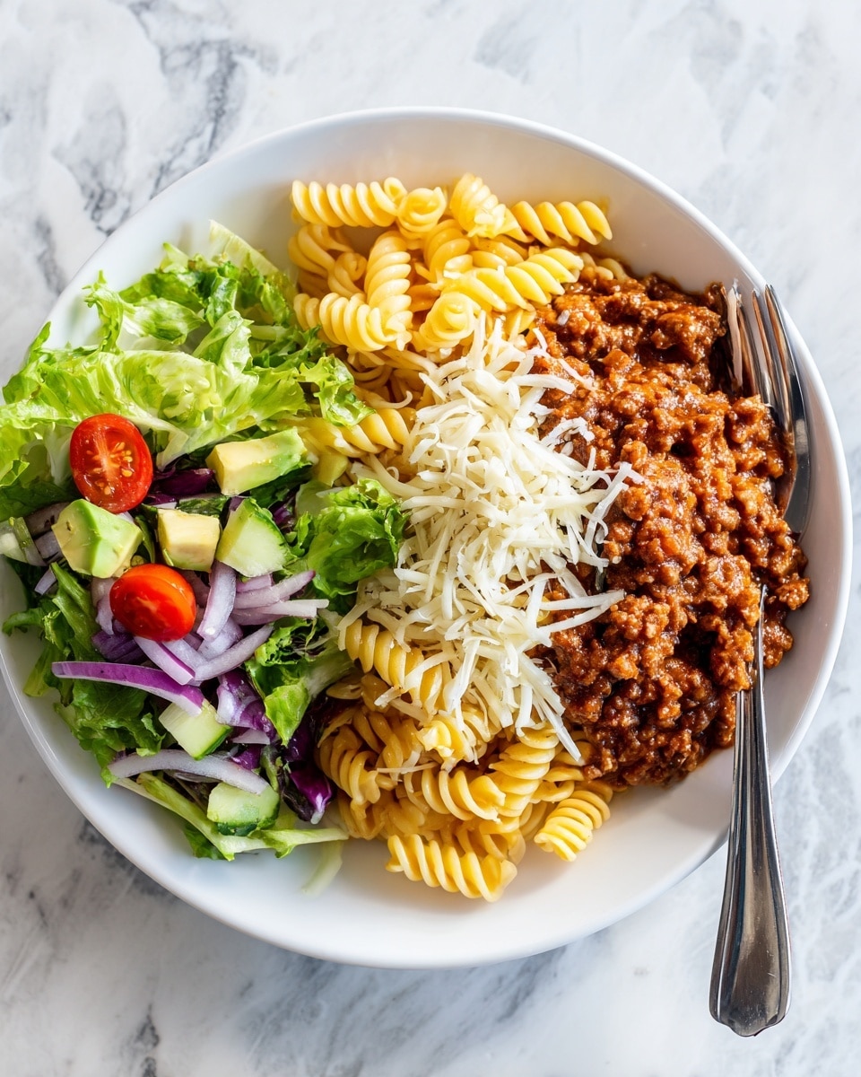 On a white plate, there is a serving of curly pasta with a layer of ground meat mixed with tomato sauce covering the pasta, topped with a light layer of shredded white cheese. To the side, there is a fresh salad made of green lettuce, light green avocado cubes, tomato wedges, cucumber slices, and thin purple onion rings. A silver fork rests on the plate’s edge. The background is a white marbled surface with a blurred half avocado and a tomato nearby. Photo taken with an iphone --ar 4:5 --v 7