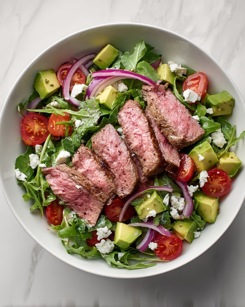 A white bowl holds a fresh salad with several layers: the bottom layer is bright green arugula leaves, scattered with small white cheese crumbles. On top, there are halved red cherry tomatoes, small chunks of green avocado, and thin slices of purple-red onion mixed evenly around. Five slices of medium-rare grilled steak, pinkish inside with a dark brown charred edge, lay neatly on top in the center. The salad looks fresh and colorful against the white bowl and white marbled surface beneath it. Photo taken with an iphone --ar 4:5 --v 7