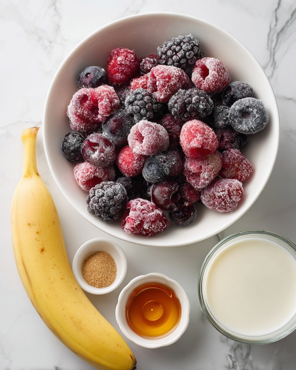 The image shows a white bowl filled with a mix of frozen berries, including raspberries, blackberries, and blueberries, all covered in frost. Nearby, there is a peeled banana placed on a white marbled surface. Next to the bowl, two small white dishes hold a syrupy amber liquid and a brown powdery spice. On the right, there is a glass cup filled with white milk. The whole setup is arranged neatly on a white marbled background with soft light. Photo taken with an iphone --ar 4:5 --v 7