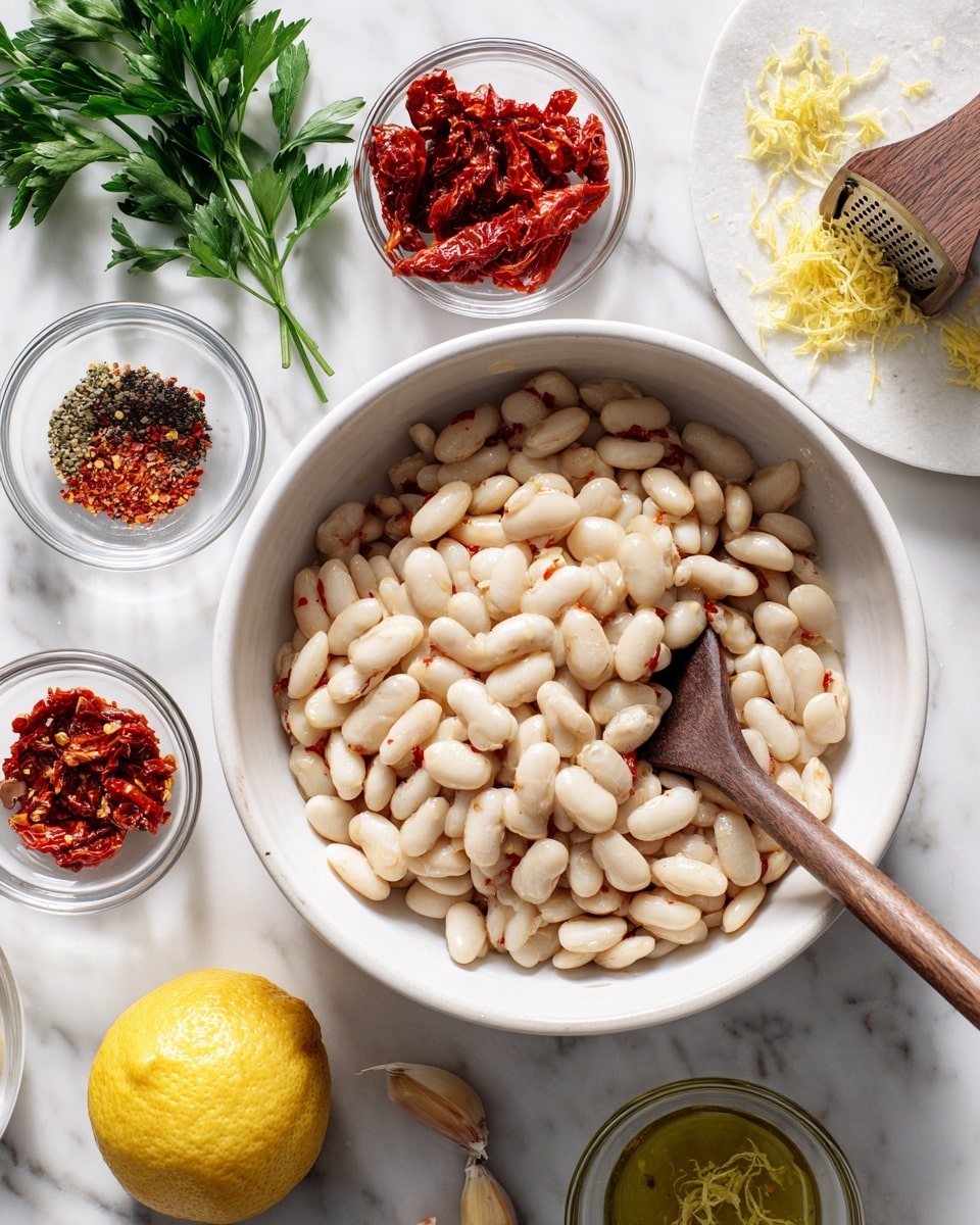 A white bowl filled with large white beans, with a wooden spoon resting inside the bowl stirring the beans. Around the bowl, there are small clear glass bowls holding different ingredients: bright red sun-dried tomatoes in oil, crushed black pepper, minced garlic, and red pepper flakes on a small white plate. A lemon half is being squeezed with a wooden lemon juicer in a small clear glass bowl next to a lemon zester with yellow lemon zest and a small pile of lemon zest on a white marbled surface. Green parsley leaves sit on the top left side on the white marbled texture background. Photo taken with an iphone --ar 4:5 --v 7