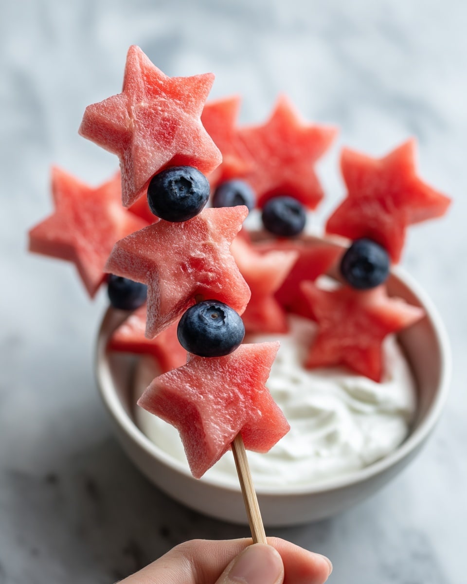The image shows several white star-shaped watermelon pieces around a small white bowl filled with white yogurt or cream. Some watermelon stars are stacked vertically on wooden skewers with small round blueberries in between each star, held by a woman's hand. The background is a white marbled surface. The colors are mainly red from the watermelon stars, blue from the blueberries, and white from the bowl and yogurt. Photo taken with an iphone --ar 4:5 --v 7