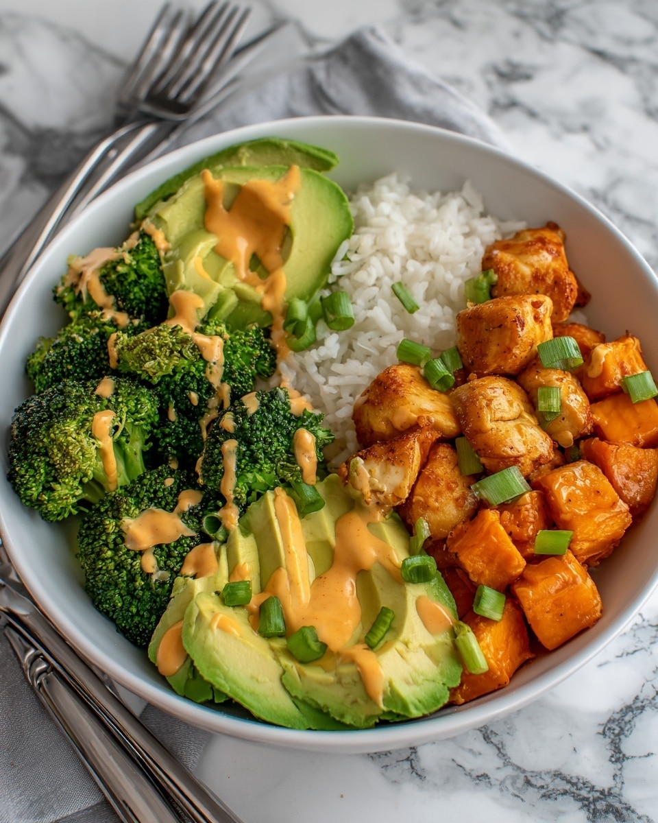 A white bowl holds four distinct layers: the bottom layer is soft, fluffy white rice filling most of the bowl’s base; on the right side, bright orange roasted sweet potato cubes create a warm block of color; next to it, golden-brown cooked chicken pieces with light seasoning are placed with a drizzle of creamy light orange sauce and chopped green onions sprinkled over; on the left side, vibrant green roasted broccoli florets with a light drizzle of the same sauce form the final layer, topped with three fresh slices of bright green avocado fanned out on top, all set on a white marbled surface with a fork and knife on a grey-striped cloth nearby, photo taken with an iphone --ar 4:5 --v 7